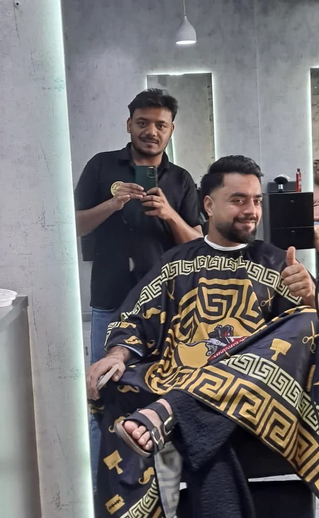 Afghanistan cricketer Rashid Khan getting a haircut at Desi Barbers, giving a thumbs up